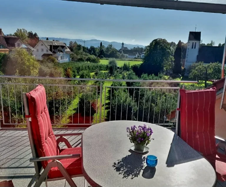 Sonniger Balkon mit Sitzplatz und Blick Richtung Wasserburger Kirche