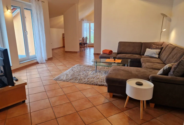 Heller Wohnbereich im Haus Sonnenseite mit Sofa, Couchtisch und gemütlicher Sitzecke