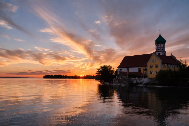 Wasserburger Halbinsel am Bodensee mit Kirche und Uferpromenade bei Sonnenuntergang