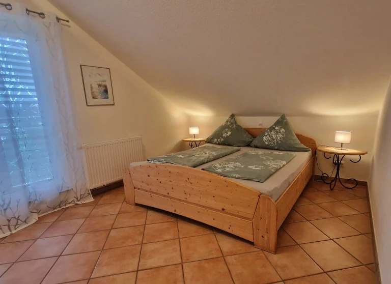 Ruhiges Schlafzimmer der Ferienwohnung Pfänder mit Doppelbett und warmem Licht
